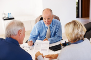 Advisor advising couple with financial papers