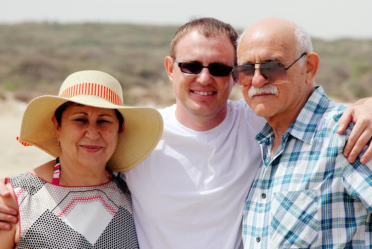 adult son with his parents walking on the beach