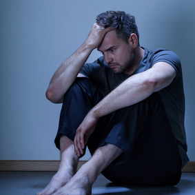 Portrait of depressed man sitting on the floor