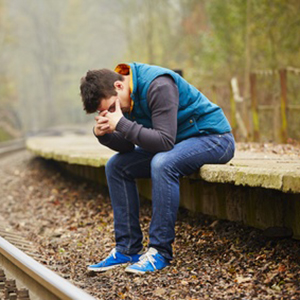 Sad young man at the railway station