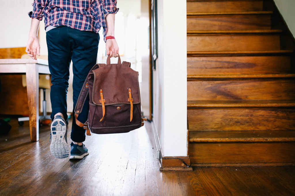 guy walking down hall with duffle bag