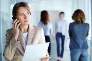 Image of agent with document speaking on the phone in working environment