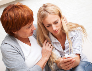 Mother soothes crying daughter. Mature woman calm young sad woman