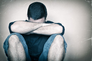 Sad young man sitting on the floor needing Good Nutrition