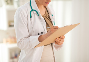 Closeup on medical doctor woman writing notes about patient's Caffeine use