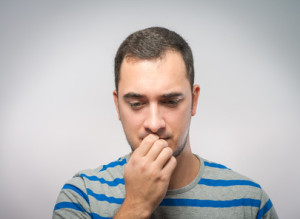 stressed mid adult man biting fingernails