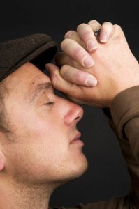 man praying with hands on head