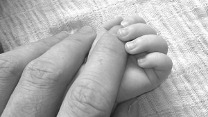 adult finger in baby's hand