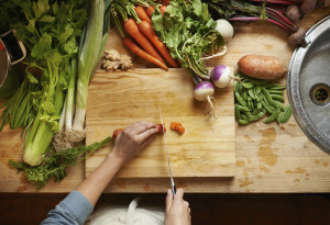 High angle shot of a woman cutting up vegetables on a cutting board