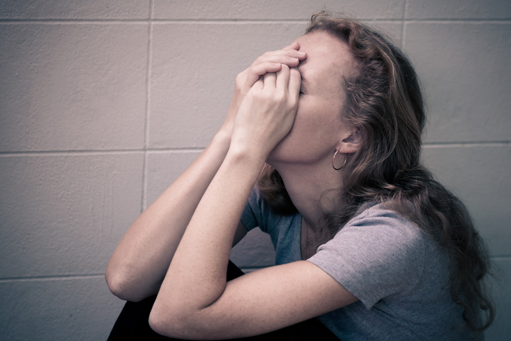 Upset Woman Sitting WIth Her Head In Her Hands