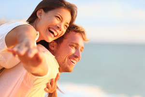 Beach couple laughing in love romance on travel