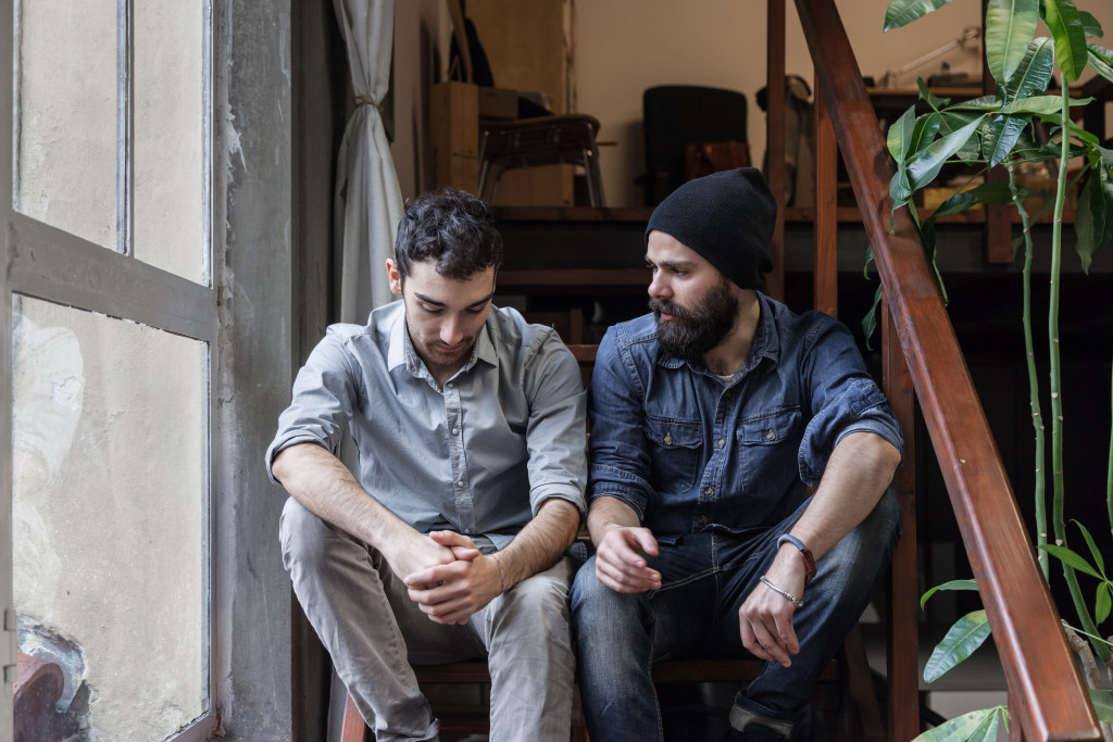 Couple of young men talking on the stairs of an office