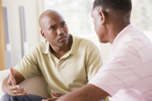 Two men in living room talking about Support Groups