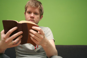 Young blond man reading the Bible