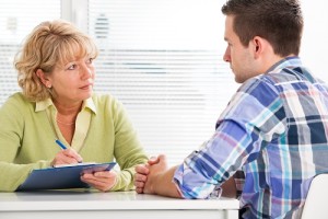 Doctor talking to her male patient at office