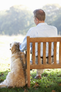 Senior man sitting outdoors with dog