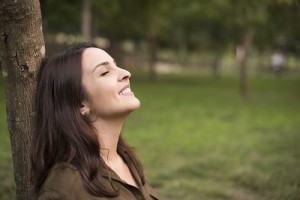 Woman with happy expression relaxing on meadow