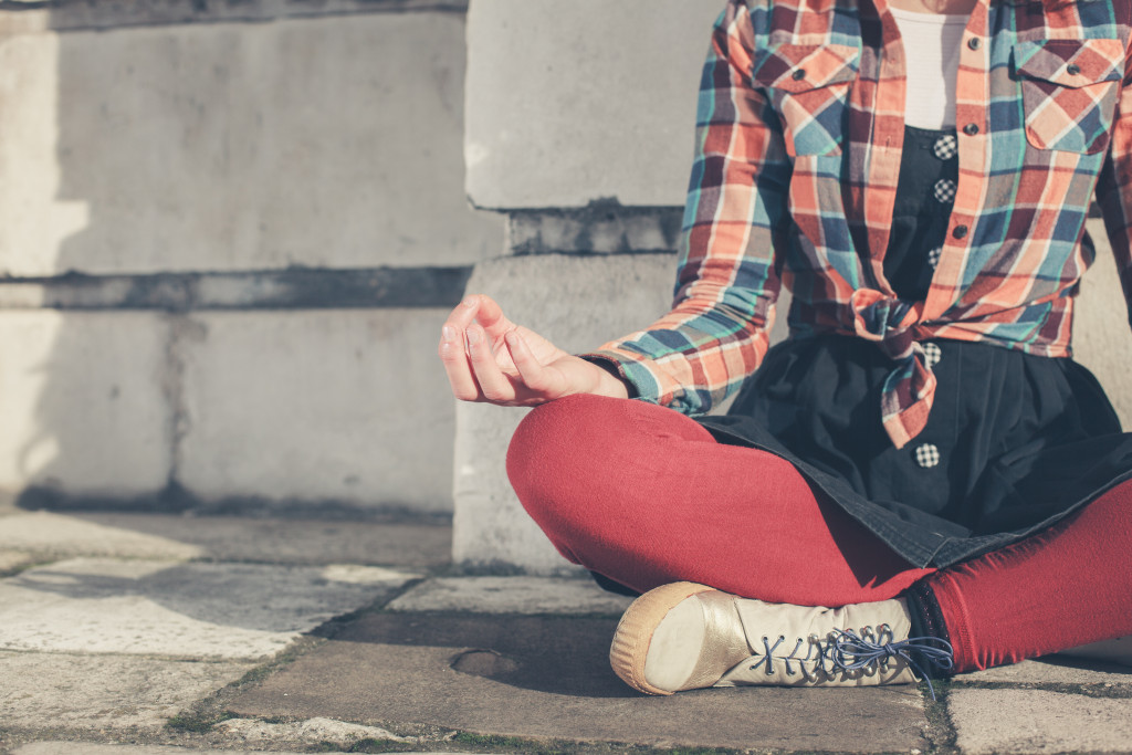 A young woman is sitting and meditating in the street