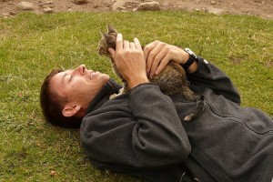 man in detox is laying on ground with cat