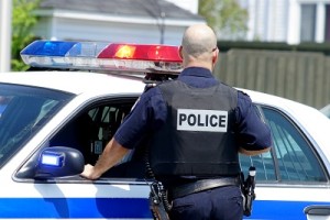 Police officer standing by patrol car thinking about his Substance Use Disorder