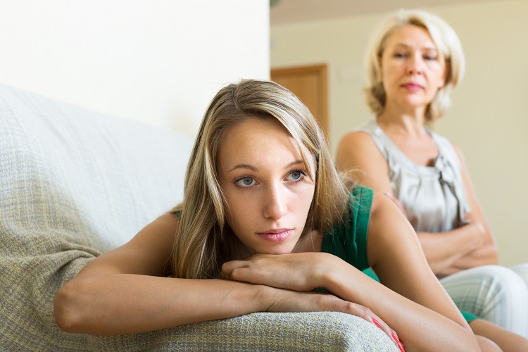 Adult daughter and aged mother after quarrel at home. Focus on young