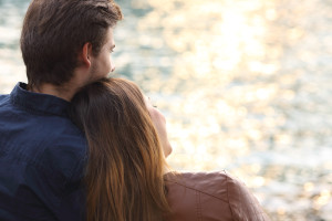 Couple hugging and watching sunset on the beach