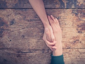 Man and woman holding hands at a table