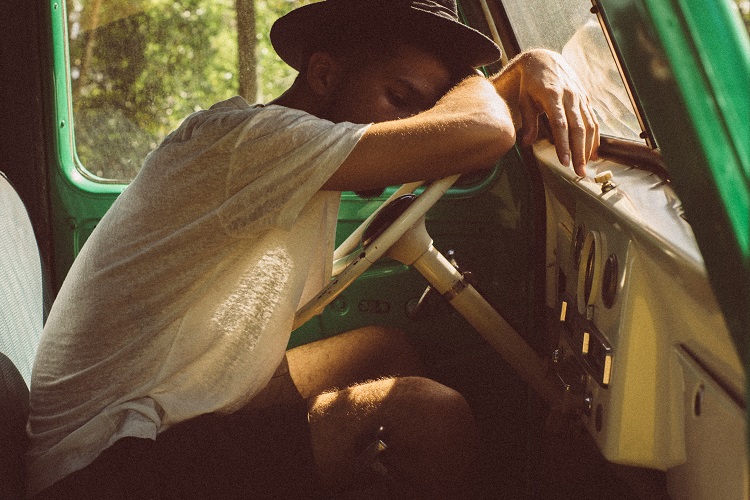 guy sleeping on truck steering wheel