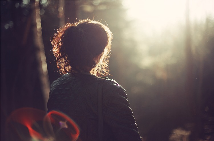 woman sitting in park at sunset