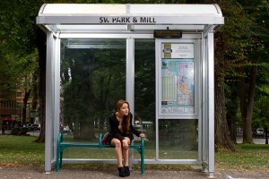 young woman sitting at bus stop