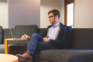 guy sitting on couch checking computer