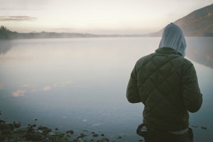 man standing near lake