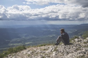 man sitting on top of high bluff