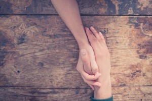 Man and woman holding hands at a table