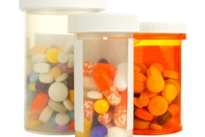 Group of three medicine bottles filled with various pills