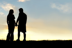 silhouette of a happy young couple in a relationship, holding hands