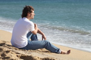 Man thinking and watching the sea on the beach