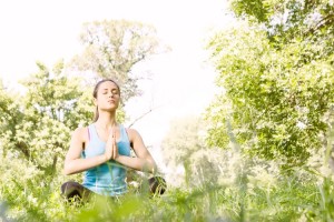 Beautiful young woman doing yoga in the park.