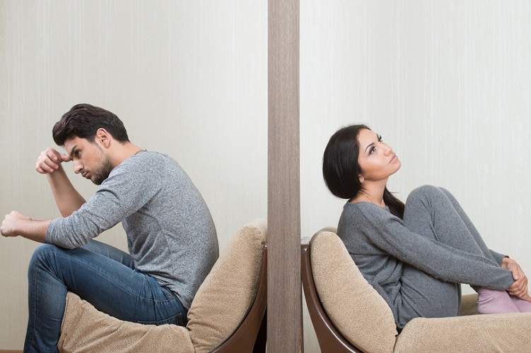 Conflict between man and woman sitting on either side of a wall