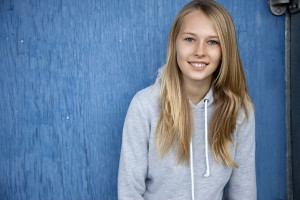 young girl smiling in hooded sweat shirt