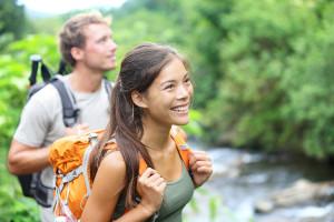 man and woman hiking forest and river