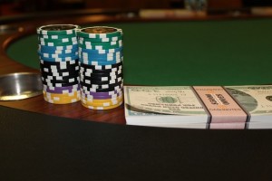 Poker chips and stack of cash on gaming table