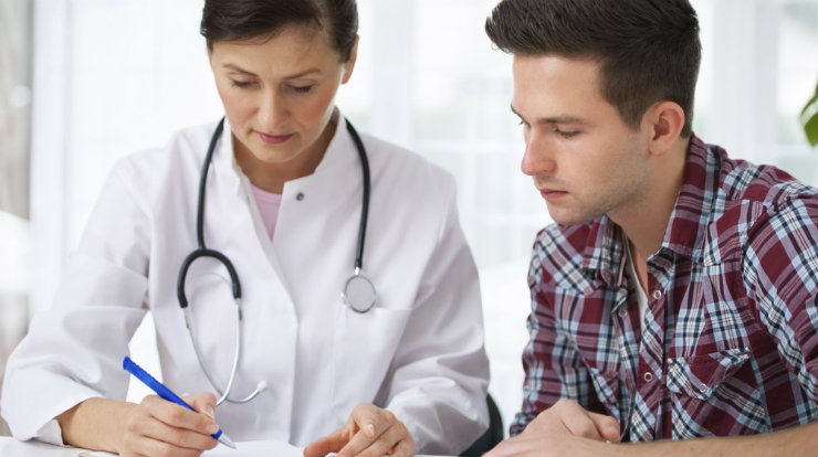 Doctor Writing Prescription For Young Man