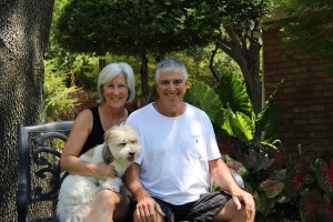 Older man with heart disease sitting with wife and dog.