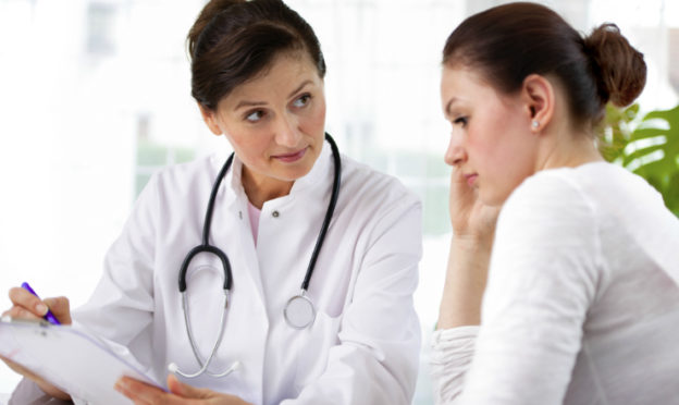 Female Doctor Working With Reluctant Woman