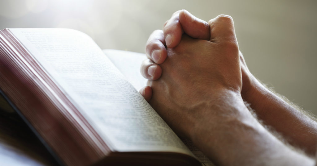 Man Praying and reading scripture