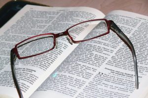 Eye Glasses resting on the bible after letting God to Change Your Character