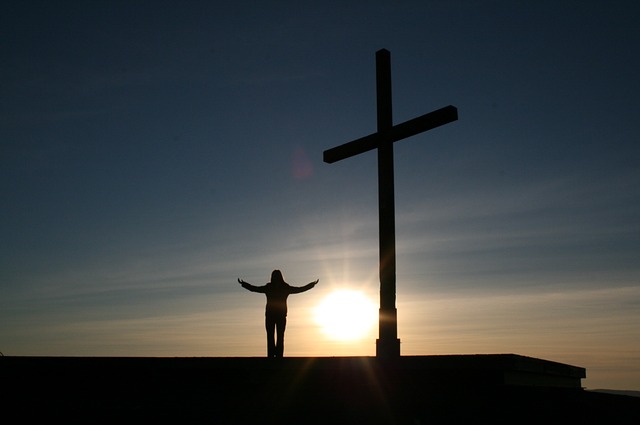 Man standing by a cross praying for God to Change Your Character