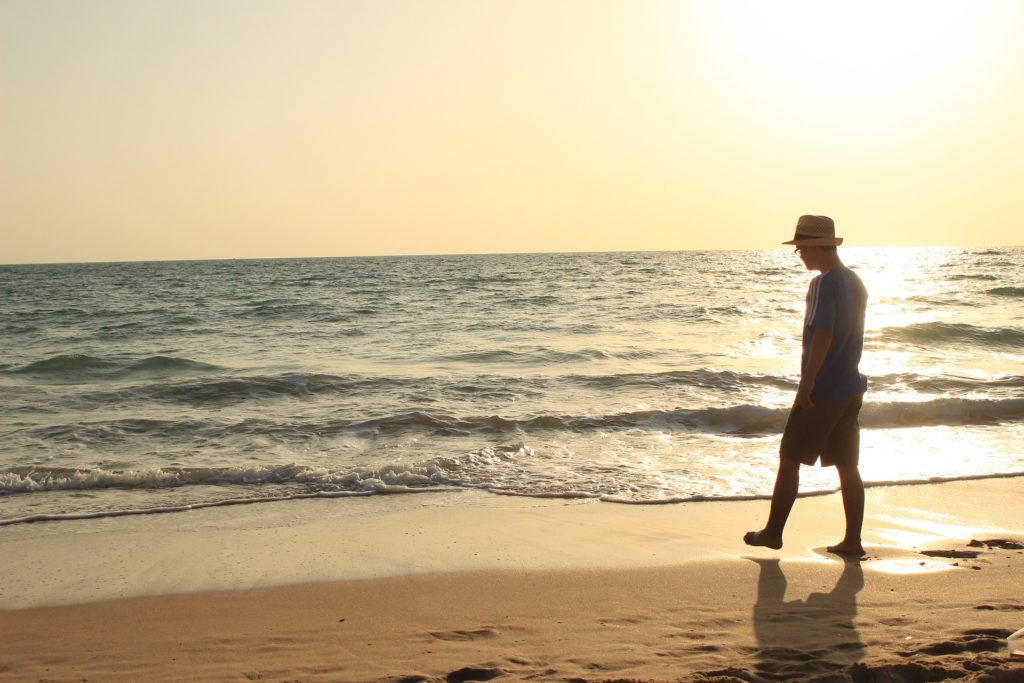 Man in addiction recovery walking on the beach