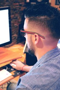 Man researching informational books on substance use and recovery on the library computer